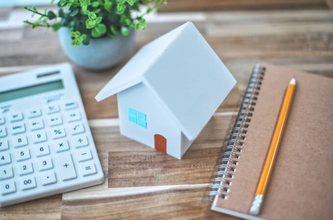 白い住宅模型と電卓と筆記用具